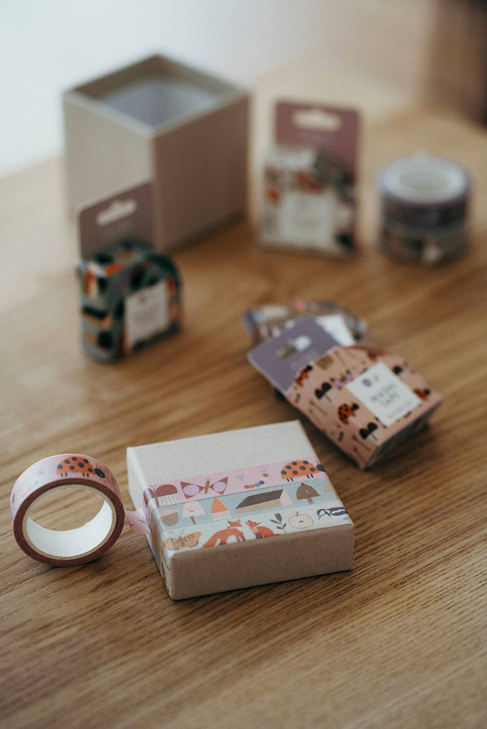 A wrapped carton lid with different masking tapes on a wooden surface