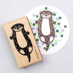 Rubber stamp with otter and printed design of an otter on a white background