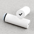 White wooden rubber stamps with a black band and check mark on a gray surface