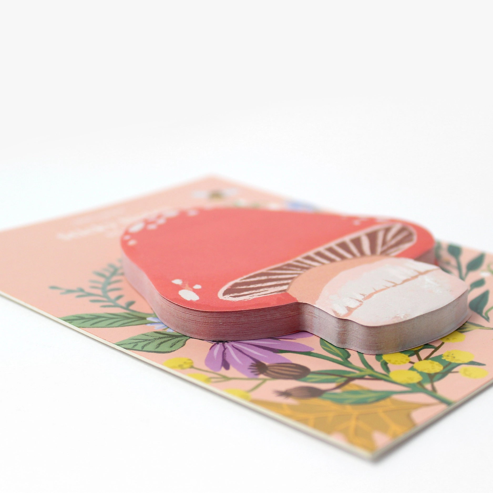Mushroom-shaped sticky notes on a floral design on a white background