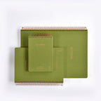 Set of green spiral-bound notebooks on a white background