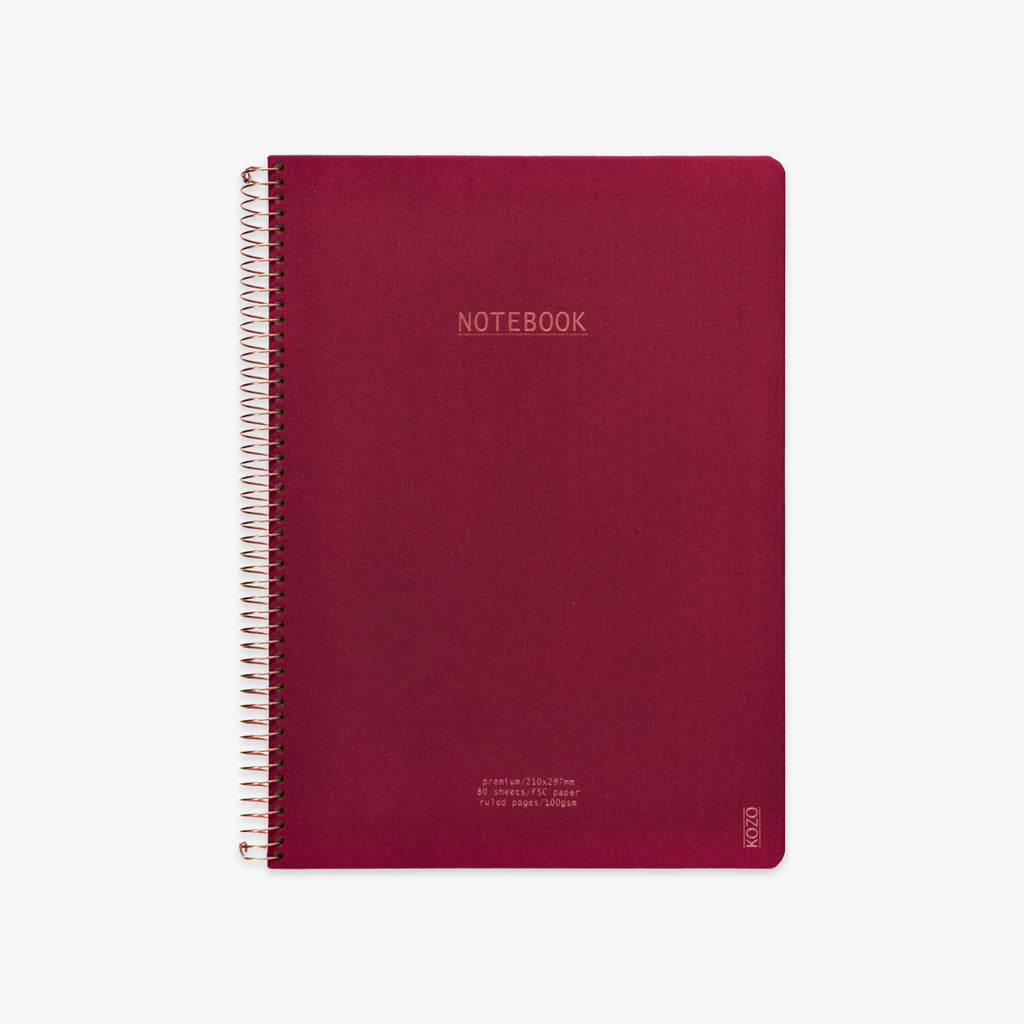 Red notebook with spiral binding on a white background