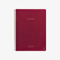 Red notebook with spiral binding on a white background
