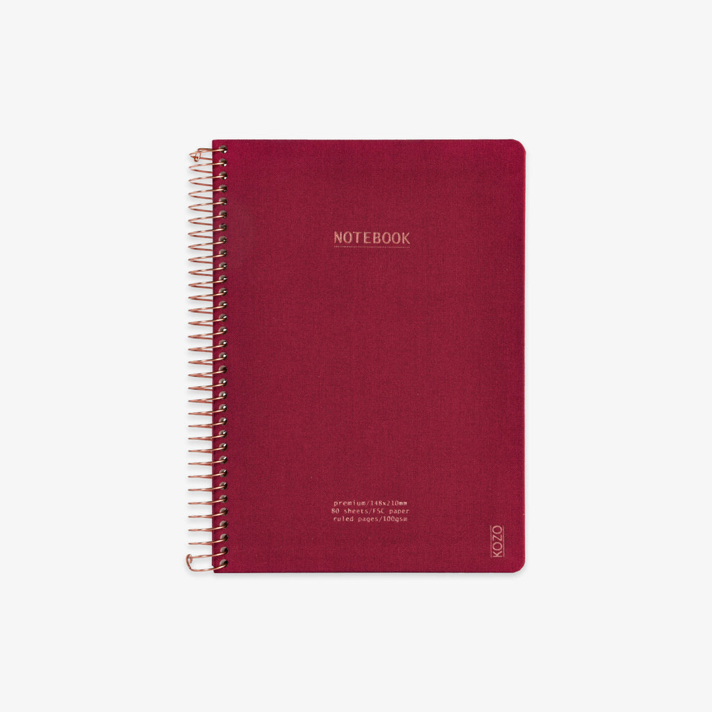 Red notebook with spiral binding on a white background