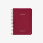 Red notebook with spiral binding on a white background