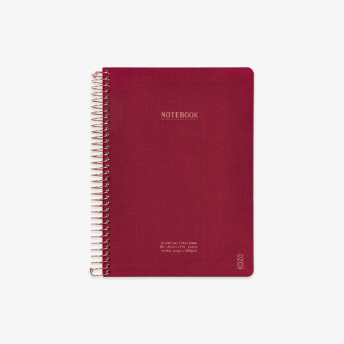 Red notebook with spiral binding on a white background