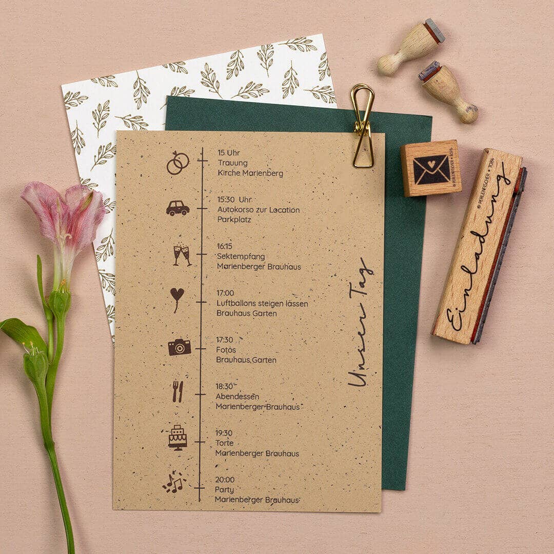 Wedding invitation with icons, stamps, and a flower on a beige background