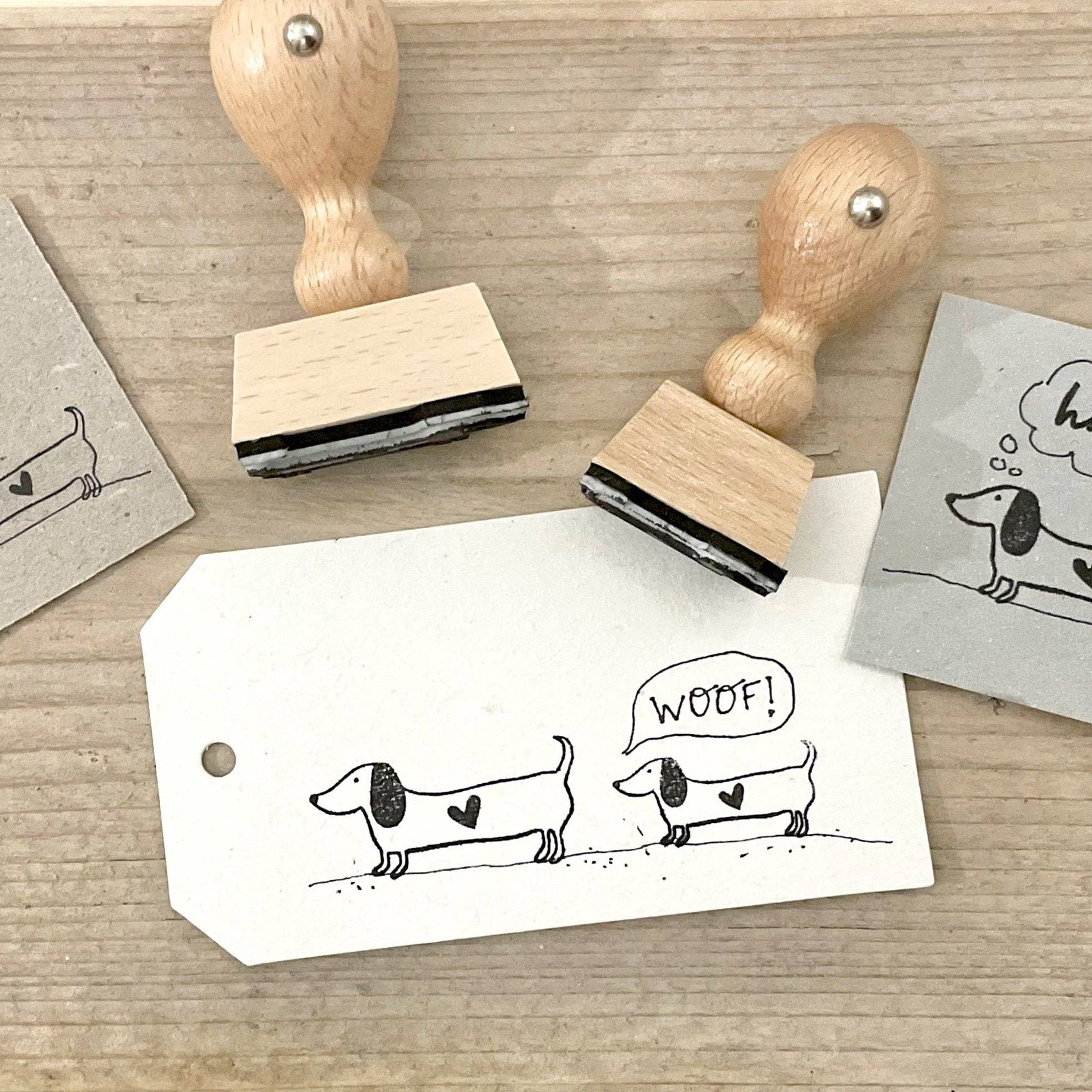 Two wooden stamps with dachshund illustrations on a wooden surface.