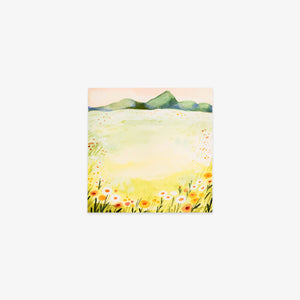 Sticky note with a landscape with mountains, fields, and flowers on a white background