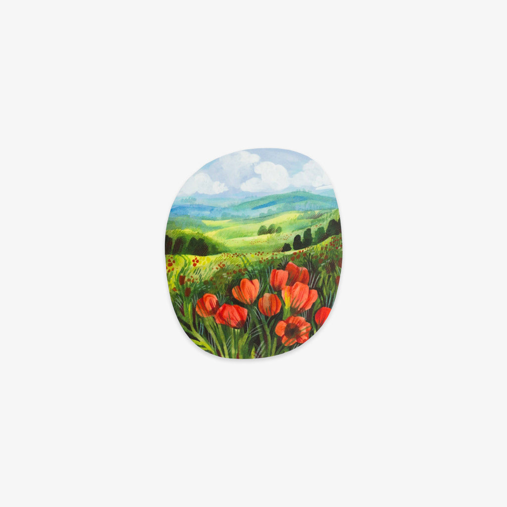 An oval-shaped sticker or decal featuring a painted landscape of red poppies in a green field under a blue sky, shown on a plain light gray background.