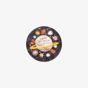 A circular sticker featuring a dark space-themed background with the text 'I need my space' on a planet, surrounded by colorful stars and a yellow ring, shown on a light gray background.