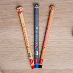 Three erasable gel pens with dog-themed designs on a wooden surface