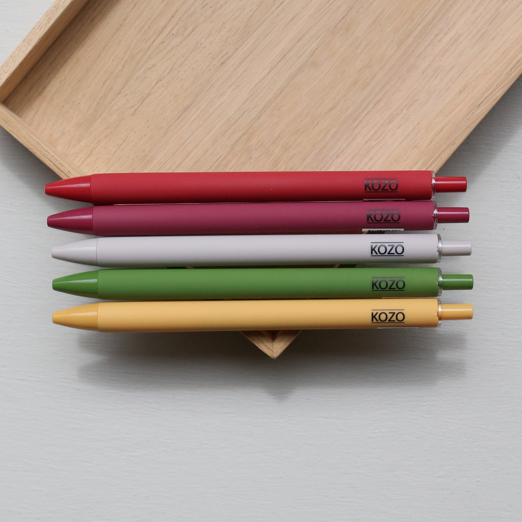 Five kozo ballpoint pens in different colours on a wooden tray