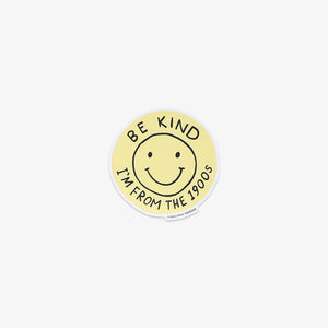 Round yellow sticker with smiley face and text 'Be kind, I'm from the 1900s' on a white background