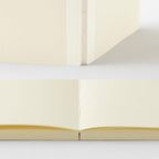 Open notebook with cream-colored pages on a light gray background