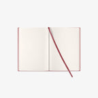 Open notebook with a red binding on a white background