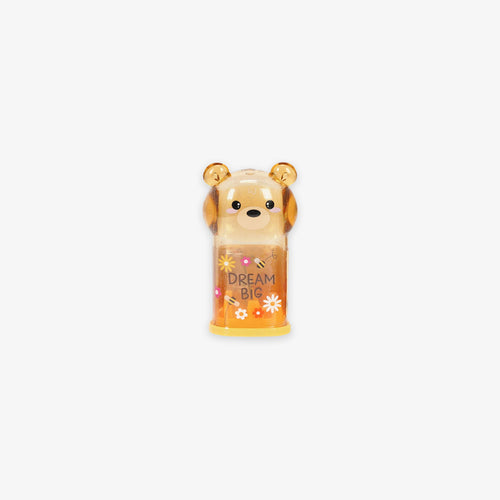 Bear-shaped pencil sharpener with the tex' dream big' on a grey background