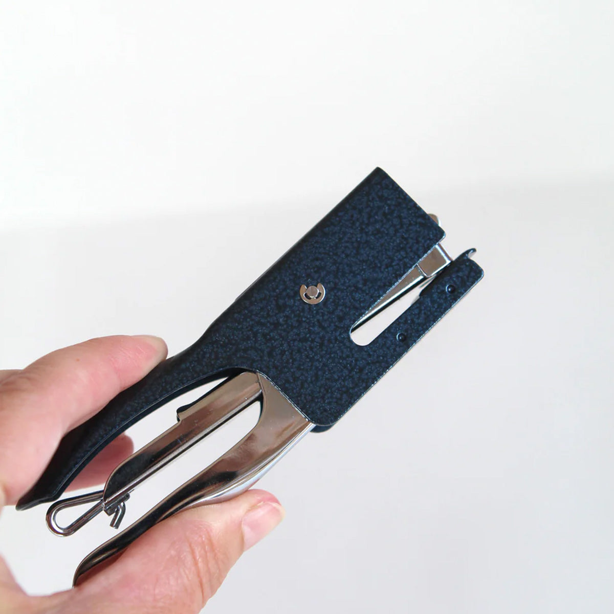 Hand holding a blue stapler 