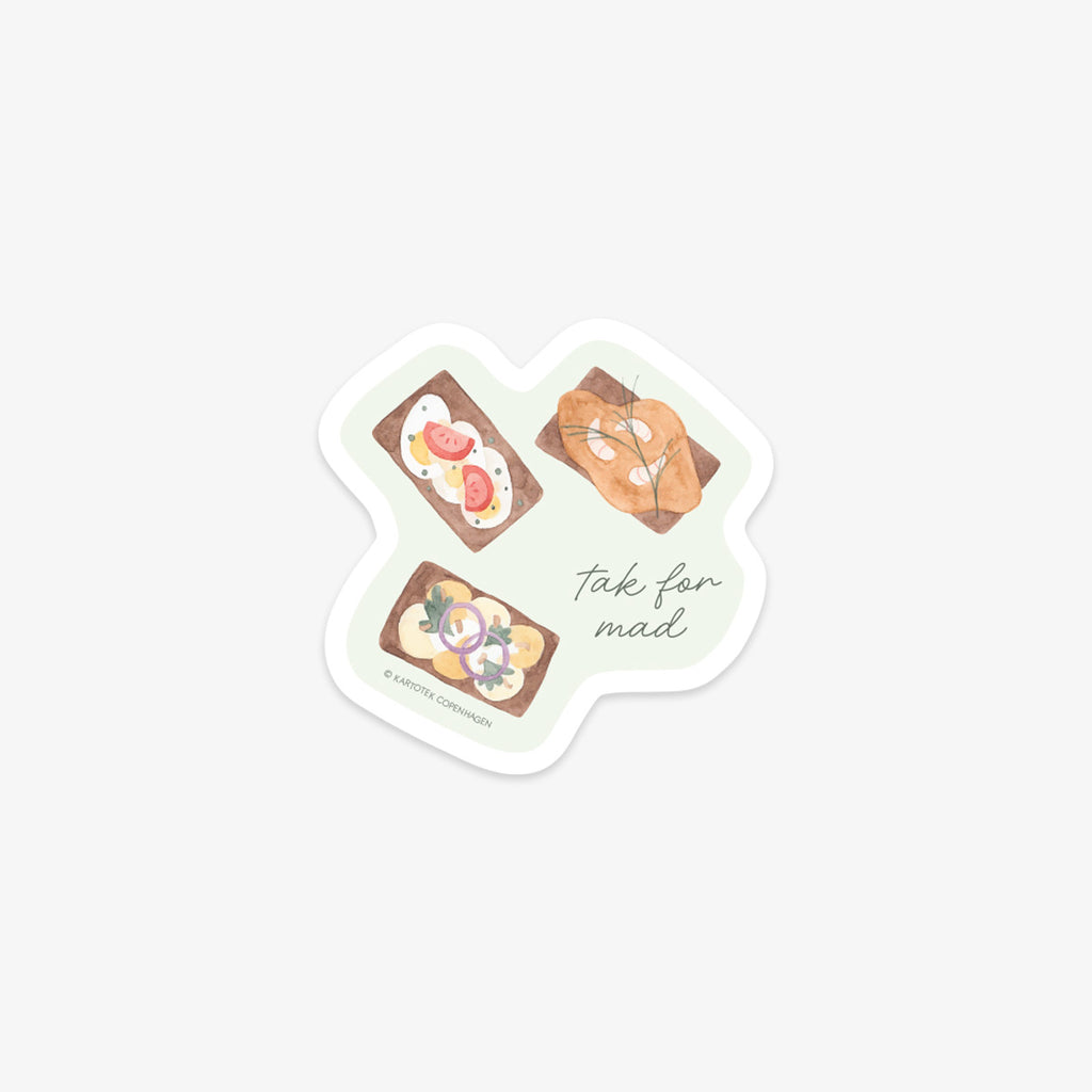 Vinyl sticker with illustrations of the Danish open-sandwishes called 'smørrebrød' and the text 'tak for mad' meaning thank you for dinner in Danish on a light green background