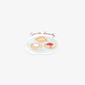 Vinyl sticker wit an illustration of a plate with Danish pastries on a white background with 'Danish, obviously' text.
