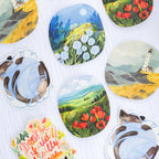 Collection of round stickers with scenic and animal designs on a white background.