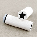 Two wooden rubber stamps with black star designs on a beige background
