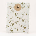 Packaging with a gold mistletoe pattern and a circular logo on a white background